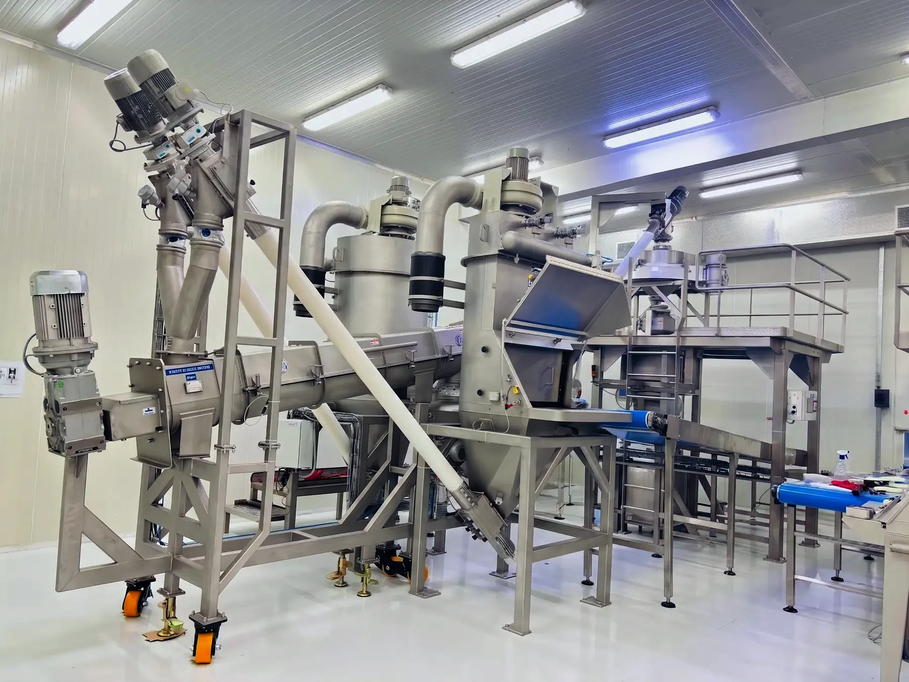 A TLG bag dumping station feeding a screw conveyor into the sifter line