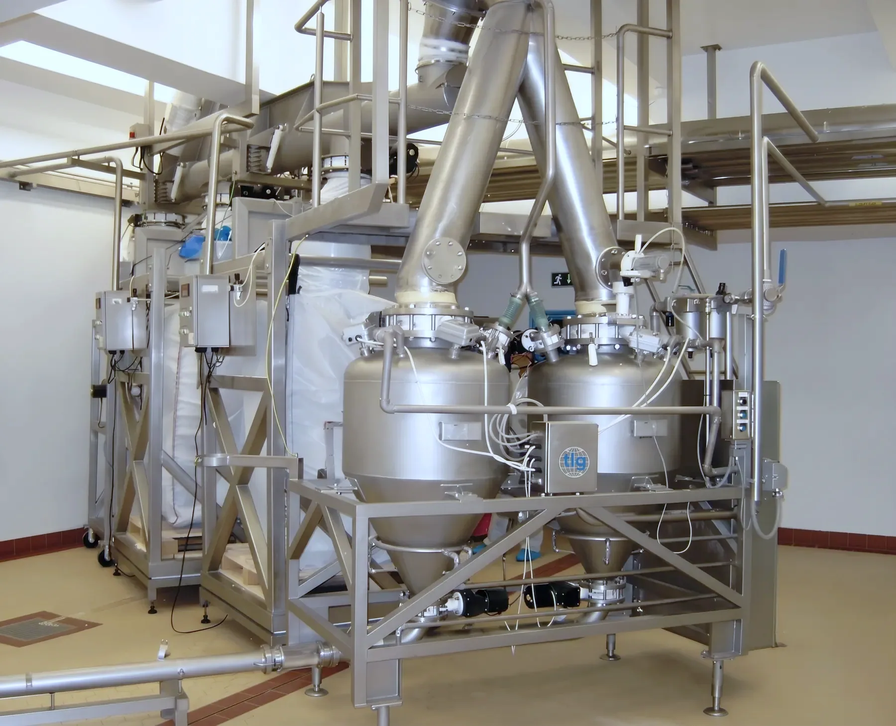 Twin TLG dense-phase pressure vessels taking powder from a bulk bag unloader above