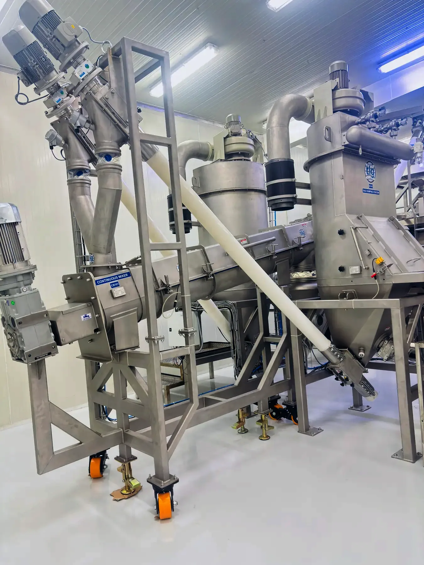Flexible screw conveyors feeding a TLG mixer off a bag dumping station